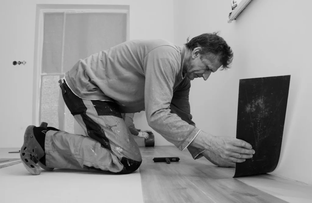 Flooring installer laying planks on the floor